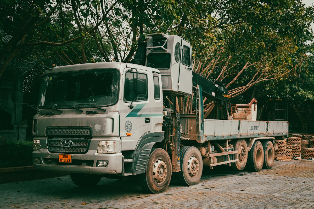 Camión con grúa pluma articulada cargando materiales